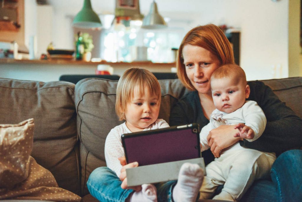 mother reading to children on sofa